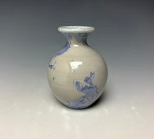 Load image into Gallery viewer, a small porcelain bud vase with a zinc crystalline glaze that has a light lavender colored crystals on a grey gradient background