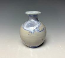 Load image into Gallery viewer, a small porcelain bud vase with a zinc crystalline glaze that has a light lavender colored crystals on a grey gradient background