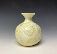 Load image into Gallery viewer, a small porcelain bud vase with a zinc crystalline glaze that has a ivory and cream colored crystals on a grey gradient background