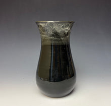 Load image into Gallery viewer, a black vase with light white, foamy looking, area along the top 1/3 of the vase. The vase is pictured on a grey gradient background.