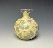 Load image into Gallery viewer, a small porcelain bud vase with a zinc crystalline glaze that has a purple base and cream and grey colored crystals on a grey gradient background
