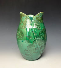 Load image into Gallery viewer, A green ceramic tulip shaped vase with a glossy finish and zinc crystals that appear as embossed floral patterns, set against a dark gray to light gray gradient background.
