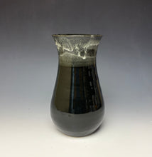Load image into Gallery viewer, a black vase with light white, foamy looking, area along the top 1/3 of the vase. The vase is pictured on a grey gradient background.
