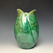 Load image into Gallery viewer, A green ceramic tulip shaped vase with a glossy finish and zinc crystals that appear as embossed floral patterns, set against a dark gray to light gray gradient background.
