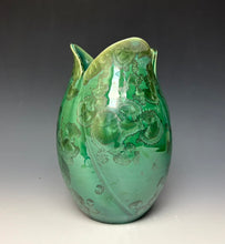 Load image into Gallery viewer, A green ceramic tulip shaped vase with a glossy finish and zinc crystals that appear as embossed floral patterns, set against a dark gray to light gray gradient background.
