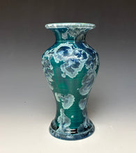 Load image into Gallery viewer, A ceramic vase with a teal and blue gradient glaze, decorated with raised white floral patterns, set against a dark gray studio background.
